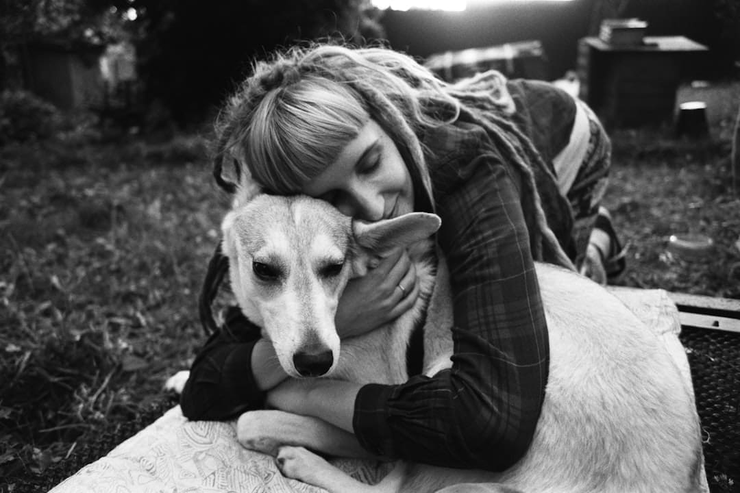 PTSD service dog. Grayscale photo of woman hugging dog